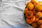 Colander with delicious ripe apricots on tablecloth, top view. Space for text