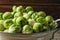 Colander with fresh Brussels sprouts on blurred background