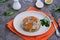 Cold appetizer, portioned jelly of pork, beef and chicken on a white clay plate on a gray concrete background. Holiday snacks for