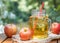 Cold apple juice in glass jar and fresh red apples