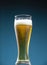 Cold beer with foam in a glass covered with droplets of water condensate