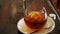 Cold brew coffee in a bottle with ice cubes in a glass tumbler on a wooden table from above. A bottle of cold brew