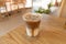 Cold brewed iced latte coffee, showing separate in a layer the bottom as milk top by coffee shot in a plastic glass on wooden