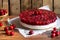 Cold cheesecake with cherry jelly on wooden background, tasty summer dessert