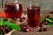 Cold cherry juice in a glass and pitcher on wooden table