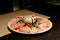 Cold Cuts Burratina: Burrata Cheese served with Parma Ham, Mortadella and Salad. Served in white plate on paper mat