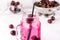 Cold Drink with Cherry in Jars on White Wooden Background Cold Detox Infused Water Summer Drink Horizontal Close Up