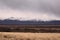 Cold, dry grasslands by the snowy Andes mountains, in Tupungato, Mendoza, Argentina, in a dark cloudy day