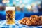 Cold full beer mug with Beirian pretzels on the wooden table covered with traditional blue and white tablecloth during Oktoberfest