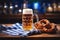 Cold full beer mug with Beirian pretzels on the wooden table covered with traditional blue and white tablecloth during Oktoberfest