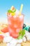 Cold grapefruit juice with ice on beach background