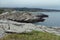 Cold grey naked smooth granite rocks with lichen, moss and shore quiet Arctic Ocean in cloudy weather, arctic landscape.