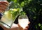 A cold lemon drink with mint leaves and fruit slices pouring into a glass