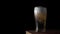 Cold light beer is poured into a glass with water drops ever matte black background, border design. Craft Beer close up