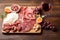 Cold meat plate and wine on wooden background