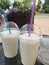 Cold milkshake with straw on summer terrace in cafe