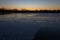 A cold morning with a beautiful warm sunrise in the Eijsder Beemden near Maastricht over a frozen lake with amazing reflections an