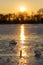 A cold morning with a beautiful warm sunrise in the Eijsder Beemden near Maastricht over a frozen lake with amazing reflections an