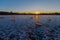 A cold morning with a beautiful warm sunrise in the Eijsder Beemden near Maastricht over a frozen lake with amazing reflections an