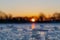A cold morning with a beautiful warm sunrise in the Eijsder Beemden near Maastricht over a frozen lake with amazing reflections an