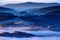 Cold morning in Sumava National park, hills and villages in the fog and rime, misty view on czech landscape, blue winter scene, Tr