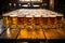 Cold mugs and glasses of beer on the old wooden table at the black background. Assortment of beer