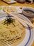 Cold noodles poured with dried seaweed in a set of Japanese dishes