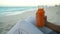 Cold pressed juice - close up of woman drinking carrot juice on beach