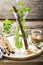 Cold refreshing Moroccan tea with cinnamon and mint in a tall decanter on a simple wooden background with a brown sugar