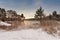 Cold snowy morning on the lake. Late autumn. Trees on lakeside