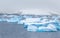 Cold still waters of antarctic sea lagoon with drifting huge blu