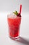 Cold straw red drink with berry and mint leaf.