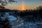 cold sunrise in winter forest with sun light pillar