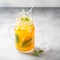 Cold tea with orange, mint and ice, sweet summer drink, refreshing lemonade, juicy cocktail. Spray, splash