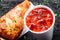 Cold tomato gazpacho soup in glass for summer with ice and Georgian khachapuri - flatbread with cheese on dark wooden background.