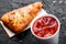 Cold tomato gazpacho soup in glass for summer with ice and Georgian khachapuri - flatbread with cheese on dark wooden background