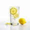 Cold vitamin water with lemon slices in a transparent glass on white background