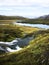 Cold water in Iceland. Stream in rocky mountains and lake side.