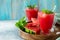 Cold Watermelon Smoothie. Summer Watermelon drink and slices of watermelon on a light stone table. Copy space