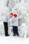 Cold winter day, boys enjoy interesting ice formations under a frozen waterfall together.