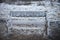 Cold winter photography image of outdoor bench or seat covered in wind swept frozen water and ice with snow background