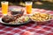 coleslaw, bbq ribs, and fries on a picnic table