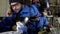 Collage close-up of a male welder in a hard hat and glasses, protective suit and gloves, who is engaged in argon welding