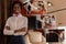 Collage of smiling african stewardess smiling at camera, putting flowers on table, giving cup of coffee