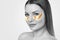 Collagen gold patches on the skin of the eyelid, on the face of a beautiful woman. Cosmetology concept. The photo is black and