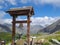 Colle Del Puriac - Mountain bike leaning against a bronze bell with panoramic view of mountain ranges of Valle Stura