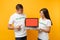 Colleagues couple in white t-shirt inscription volunteer hold laptop pc computer, blank empty screen isolated on yellow