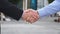 Colleagues meet and shake hands in the city background. Two businessmen greeting each other in urban environment