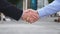 Colleagues meet and shake hands in the city background. Two businessmen greeting each other in urban environment