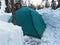 Collected green tent in the forest in winter. Overnight in a tent in extreme conditions. Tourism for people of strong
